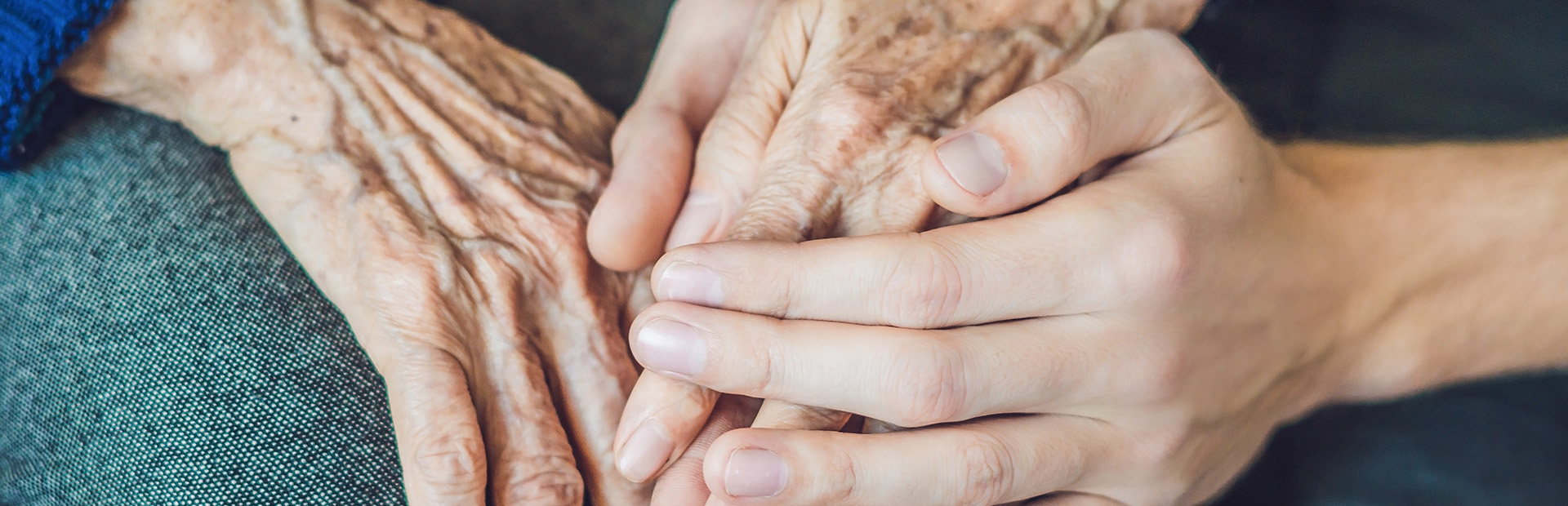 Hands of an old woman and a young man. Caring for the elderly. close up